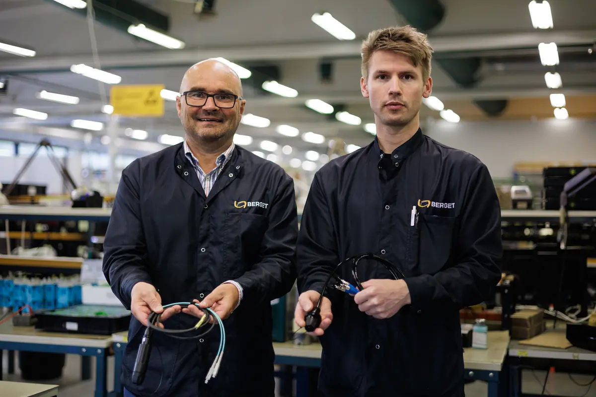 To ansatte med ferdige kabler i produksjonshallen på Høgås
