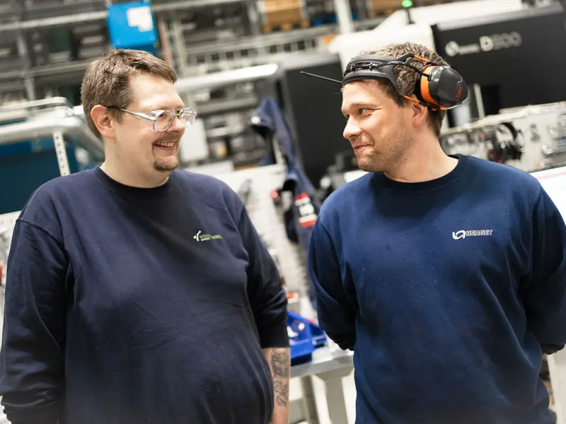 To CNC-operatører i samtale ved maskinene