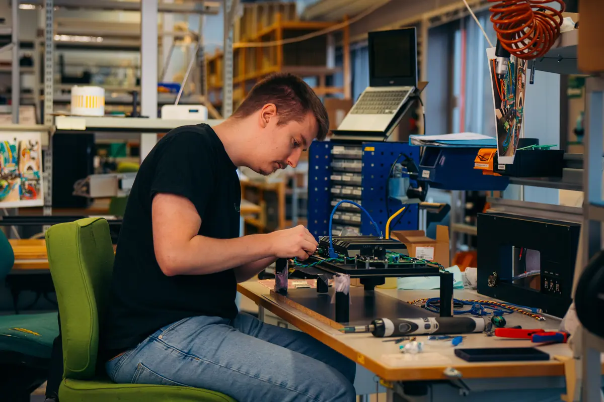 Lærling ved en arbeidsbenk med elektronikk