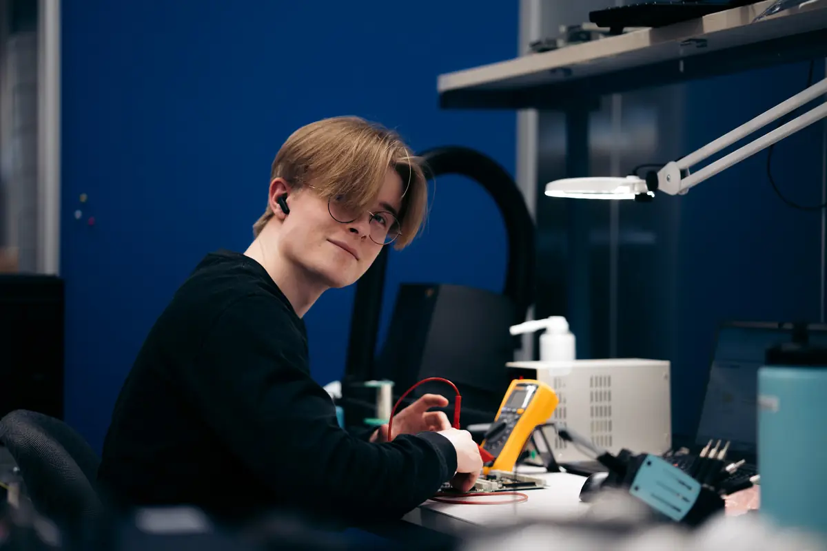 Young employee testing electronics at a workbench