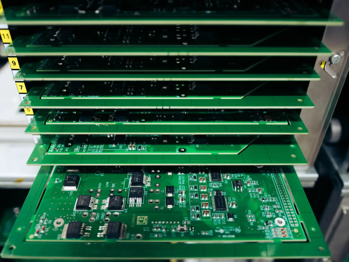 A stack of populated green circuit boards in a magazine