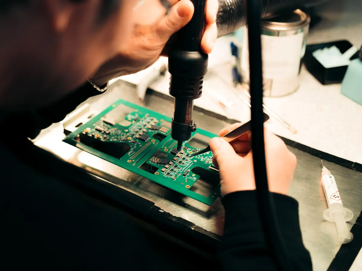 Hand soldering a component on a circuit board under magnification